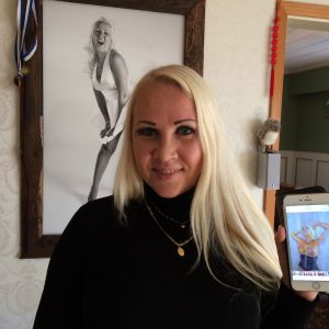 Kvinna håller i telefon där en erotisk målad bild av henne visas