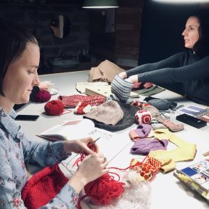 Två damer stickar mössor på Feministiska stickklubbens möte i Tallinn