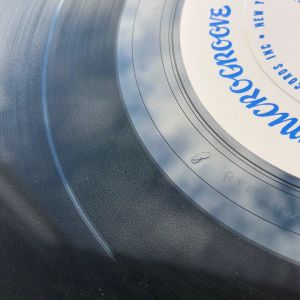 Lägg märke till det snirkliga "örat" i mellanrummet mellan spåren och etiketten vinylskiva