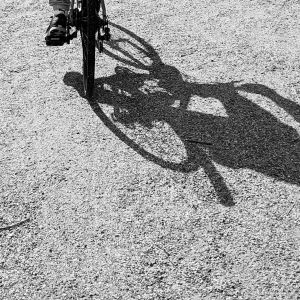 Det kan hjälpa att röra på sig, när ångesten sätter in. Kroppen får en annorlunda upplevelse och mår kemiskt bättre, säger krisarbetare Charlotte Wieliczko. En fot som trampar en cykel över grus och cykelns skugga är enorm på grusplanen.