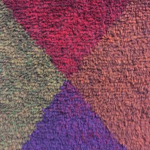 Detalj av ryan "Fyra färger" från 1965 av Uhra-Beata Simberg-Ehrström, vars ryor är eftertraktade idag. Hennes verk uppskattas för deras vibrerande färgvärldar. Detalj av en ryas nockor.