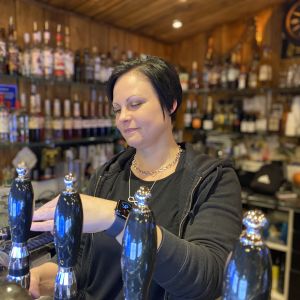 Heidi Pirhonen Pub Härmän Häjyn baaritiskin takana laskemassa oluthanasta olutta.