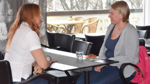 Paula Agge från bemanningsföretaget Nurse Partner och Daniela Laiho diskuterar ett eventuellt jobbpass i Sverige Paula Agge från Nurse Partners sitter vid ett bord och pratar med Daniela Laiho som sitter mittemot i samma bord.
