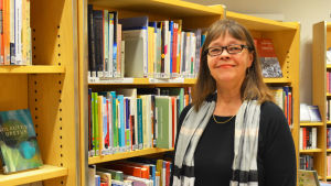Biblioteksdirektör Margareta Kull-Poutanen hoppas få öppna det nya biblioteket under våren 2020. Bibliotekschefen Margareta Kull-Poutanen ser nöjd ut. Står framför bokhyllor.