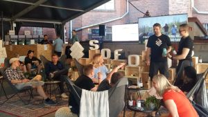 Kommer det alltid att finnas möjlighet att delta på distans i framtiden? Unga vuxna sitter i säckstolar och solstolar på en business- och framtidsfestival.