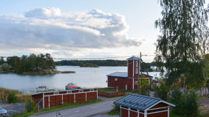 Gumbovägen leder ner till Gumbostrand. Utsikten från Gumbohuset en vacker septemberkväll, hav, båtar, FBK.s röda torn.
