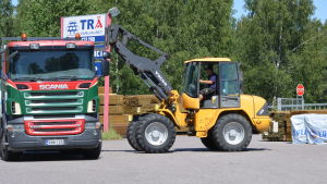 Visst säljs det byggmaterial också i Ekenäs, men mängderna har minskat. En traktor lastar på en lastbil på en gårdsplan som hör till ett trävaruföretag.