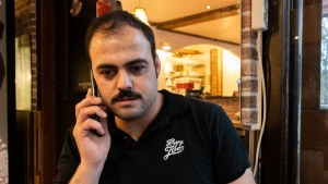 Upp till tolv timmar sätter Armand Haji varje dag på sitt företagande. Armand Haji talar i telefon.