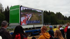Publiken på tävlingsplatsen följer på en storskärm med hur Alexandra Enlund växlar. Publiken följer med Venlakavlens växling på en storskärm.