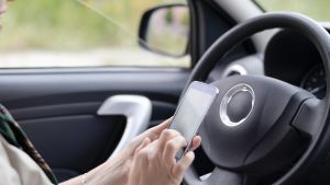 Polisen övervakar även bilisternas mobilanvändning i trafiken. En businesskvinna sitter i en bil och skriver ett sms.