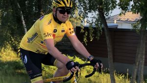 Christer Holmlund har långa dagar av cykling framför sig då resan mot Paris börjar. Christer Holmlund cyklar på en cykel. Han har färgglada cykelkläder på sig.
