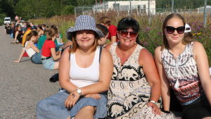 Sandra, Laura och Karin Veijola ställde sig i kö kvart före nio på morgonen. Sandra, Laura och Karin Veijola sitter i solen.