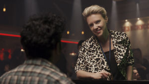 Managern Debra (Kate McKinnon) ler vänligt och tänker på alla dollars hon nu ska förtjäna. Managern Debra (Kate McKinnon) ser glad ut.