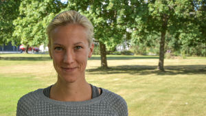 Elitidrottare Camilla Richardssson har bra erfarenheter av sin tid som barn och ung inom friidrotten. Men hon har hört om andra som inte har haft lika tur. Camilla Richardsson tittar in i kameran och ler. Grönskande träd och gräs i bakgrunden.