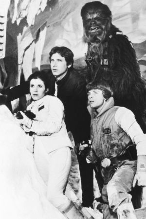 I bakre raden Peter Mayhew i rollen som Chewbacca, tillsammans med de övriga huvudkaraktärerna i de tre ursprungliga filmerna, Han Solo (spelad av Harrison Ford), Leia Organa (Carrie Fisher) och Luke Skywalker (Mark Hamill). Fotografiet är taget under inspelningen av den andra Star Wars-filmen The Empire Strikes Back (på svenska: Rymdimperiet slår tillbaka) som kom ut år 1980. Star wars-karaktärerna Han Solo, Leia Organa, Luke Skywalker och Chewbacca.