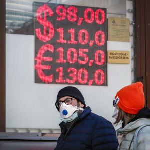Ihmiset kävelevät valuutanvaihtopisteen edustalla Moskovassa.