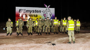Gränsen vid Åbo motorväg är stängd och bevakas av polis och beväringar. En grupp beväringar samlas i kvällsbelysning vid Nylandsgränsen.