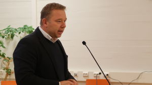 Enligt Niklas Guseff bör beslutsfattarna använda tiden klokt innan reformen träder i kraft. Niklas Guseff vid talarstolen.