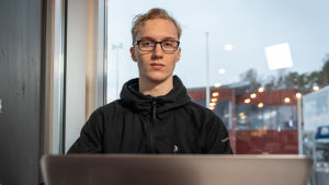 Abin Hugo Rots insåg på gymnasiets första kurs i psykologi att han hittat sitt drömyrke: psykolog. "Jag kan tänka mig att andra elever får liknande insikter på kurser i till exempel historia eller filosofi", säger han. Manlig gymnasieelev med glasögon och svart collegetröja framför en laptop.