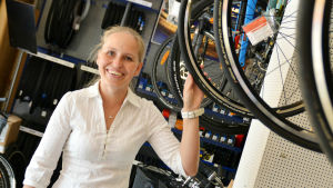 Susanne Westerholm tror att klimatförändringen får folk att välja cykeln. Susanne Westerholm står omringad av cyklar.