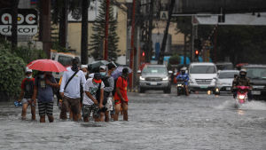 I Manilaförorten Makati går människor omkring i vattenmassor. Människor i vattenmassor i samband med översvämning i Makati, Filippinerna