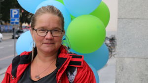 Nuorehko nainen ilmapallojen edessä Turun pääkirjaston ulkopuolella.