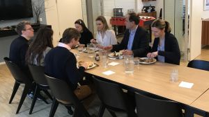 På Lotta Nymann-Lindegrens arbetsplats levereras lunchen till kontoret Kolleger äter lunch tillsammans vid ett matbord på kontoret.