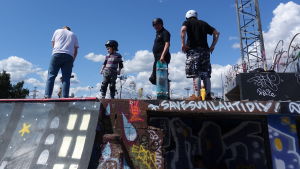 Skejtparken i Södervik är rivningshotad. Fyra personer i olika åldrar som står med sina skatebrädor och med skyddsutrustning i skateparken i Södervik, Helsingfors.