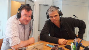Konstnärerna Lasse Lampenius och Larson Österberg. Lasse Lampenius och Larson Österberg sitter i en radiostudio med hörlurar på.