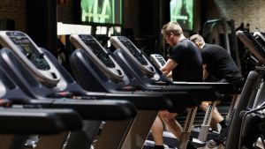 Hurdana coronarestriktioner som ska gälla på till exempel gym har vållat huvudbry. Två män sitter på konditionscyklar i ett tomt gym.