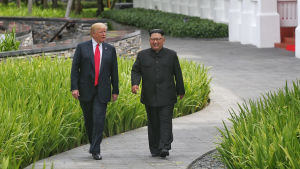 Det första toppmötet i Singapore slutade i en vag deklaration om kärnvapennedrustning på den koreanska halvön. Donald Trump och Kim Jong-un promenerar längs med en stig.