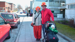 Mamma Pia Solback, pappa Kim Nordling och lilla Mia Nordling på väg för att titta paraden. En familj utklädd inför valborg.