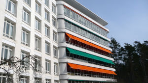 Sanatoriet räknas som ett lysande exempel på funkisarkitekur. En gammal sjukhusbyggnad med gröna och orange markiser vid fönstren.