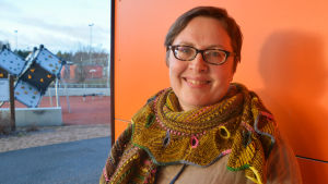 Hanna Graeffe fick i år pris för sitt jobb med svenska av OKKA och Svenska kulturfonden. kvinna i grann sjal framför orange vägg