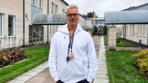 Peter Waltonen är lärare i Prakticum. En man i vit munktröja står på en skolgård.