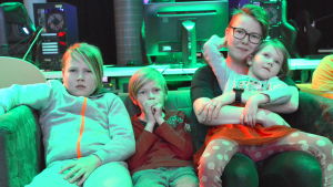 Suvi Vainio och barnen Arttu, Vertti och Siiri spelade olika spel tillsammans och var för sig. Kvinna med tre barn i en soffa.