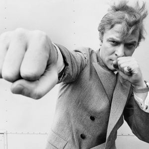 Michael Caine poseeraa nyrkki kohti kameraa (1965)