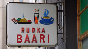 Billig mat vill många ha - en del restauranger klarar det genom olagliga löner till utländsk arbetskraft. Gammaldags matbarssskylt i Berghäll i Helsingfors