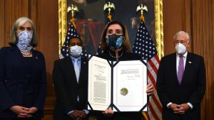Representanthusets talman Nancy Pelosi håller upp dokumentet med beslutet att dra Trump inför riksrätt. Nancy Pelosi håller upp dokumentet med beslutet att ställa Donald Trump inför riksrätt.