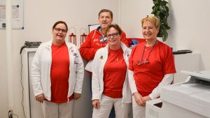 Ansvarig laboratorieskötare Carina Gustafsson, läkare Bernhard Edgren, laboratorieskötare Ann Liljestrand och sjukskötare Marina Vuorela. Personalen på en läkarcentral poserar i receptionen.