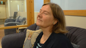 Yvonne har alltid varit intresserad av att hjälpa andra människor. En kvinna sitter i en soffa och blundar.
