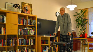 Rolf Lindström framför avdelningens gemensamma tv. En äldre man med rullator framför en tv.