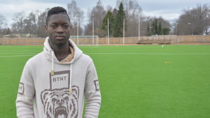 Mohamed Doumbias favoritlag är Real Madrid. Men han skulle helst spela i Liverpool. Ung man i ljus munkjacka på konstgräsplan