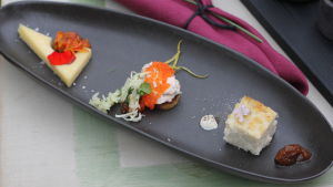 Tyrnimarjat, kalanmäti ja riisipuuro ovat vain muutamia pohjoismaisen keittiön aineksia, jotka
sopivat mainiosti yhteen saken kanssa. Serveringsfat med tre tilltugg av lax, pannkaka och ost.