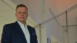 Vice prefekt Micael Vuorio vid yrkeshögskolan Novia. En man med ljust hår står i en trappa.