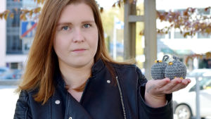 Cassandra Lindén har testat de virkade bona i hundkojan där hemma. Dit har getingarna inte återvänt efter att det riktiga boet ersattes med ett i garn. Cassandra Lindén håller i två virkade bollar som ser ut som getingbon.