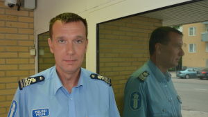 Överkommissarie Stephan Sundqvist. En man med polisskjorta på står framför en dörr.