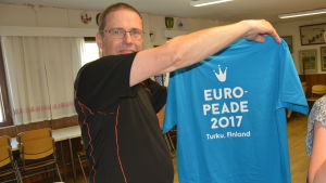 Pargasbon Sten Sirén då han var på väg till Europeaden i Belgien i fjol. Sten Sirén visar upp tröjan som danstruppen ska bära.