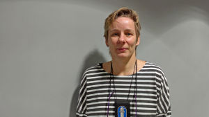 Pauliina Kääntee från Helsingforspolisen. kriminalöverkonstapel pauliina kääntee mot grå bakgrund