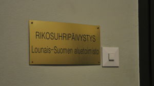Brottsofferjouren finns i Åbo centrum. En skylt i guld med texten Rikosuhripäivystys som finns utanför brottsofferjouren i Åbo.